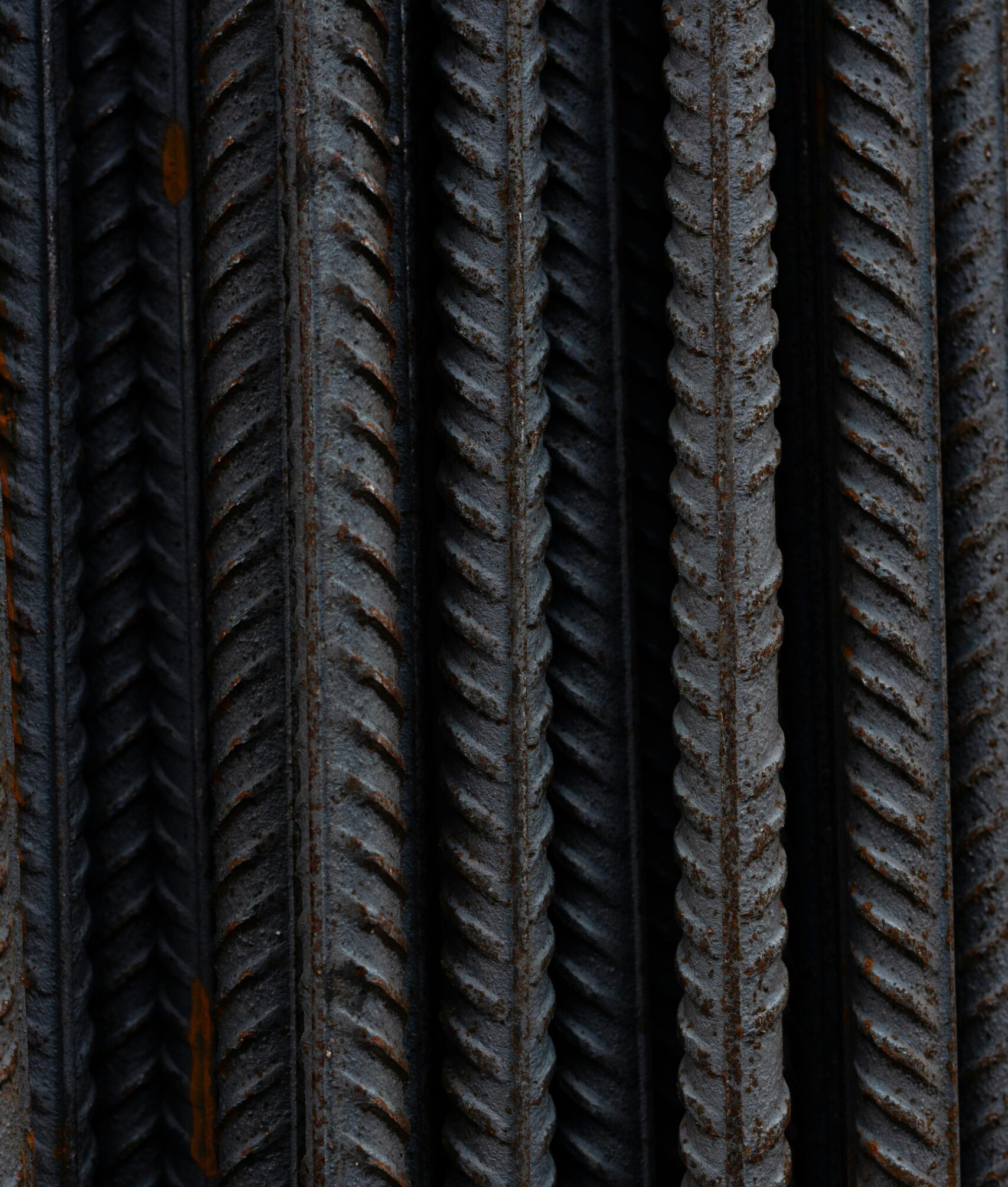 Detailed shot capturing the texture and rust of vertical steel bars in a bundle.